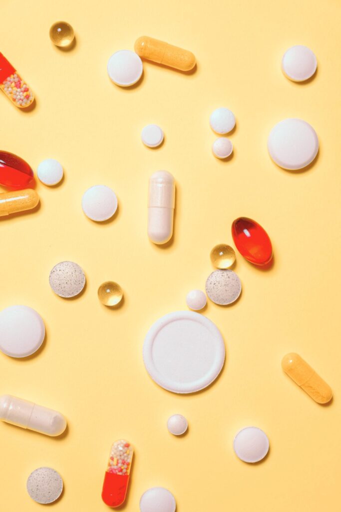 Rozrzucone tabletki i lekarstwa na jasnopomarańczowym tle