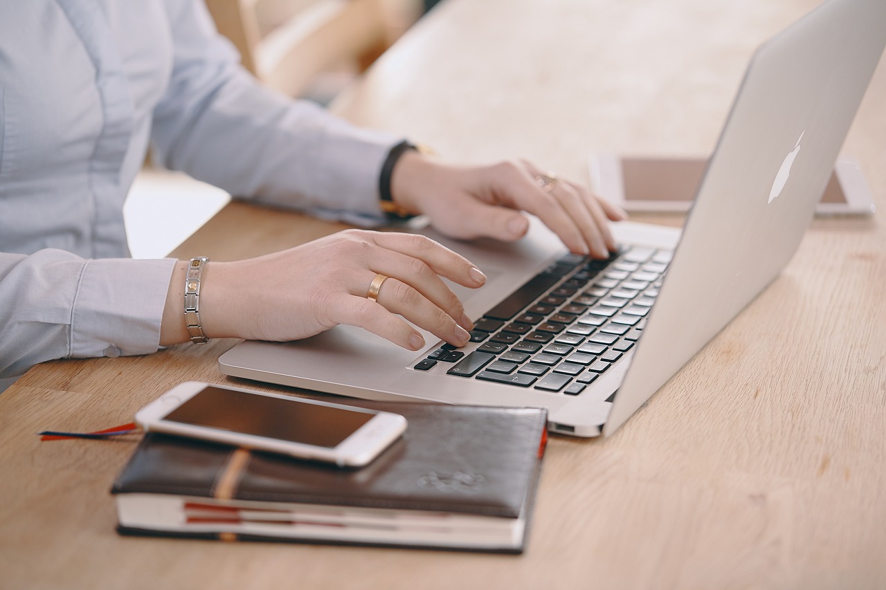 wdrożenie i prowadzenie bdo - kobieta pisze coś na laptopie, a obok leży komórka i notes