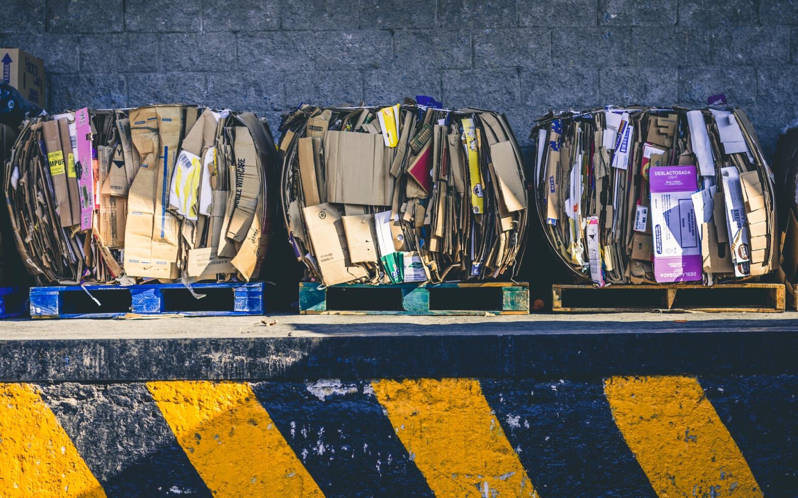 przetwarzanie odpadow - zbelowana makulaturya w postaci kartonów jest gotowa do recyklingu i przetworzenia; stoi na paletach